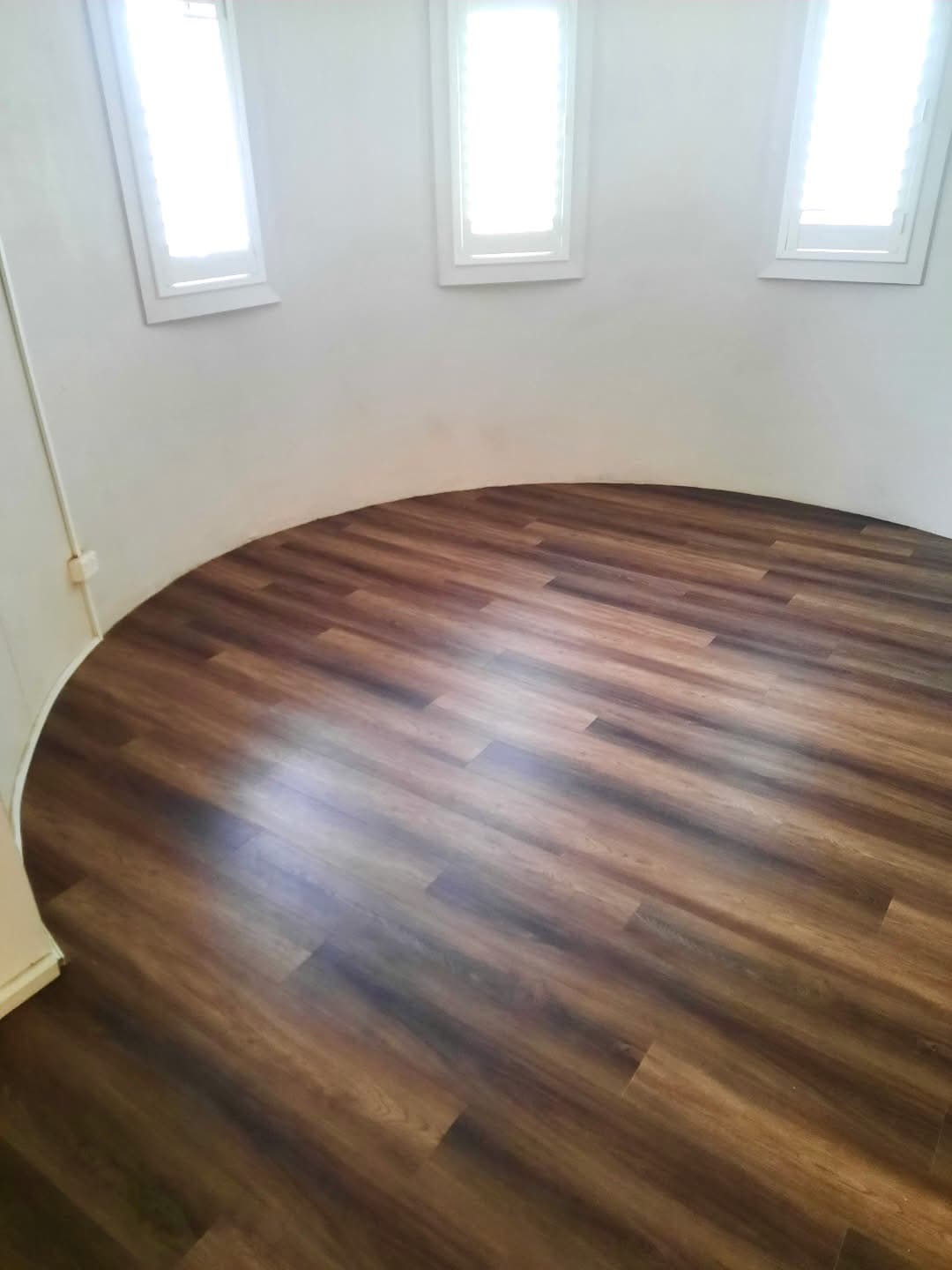 Curved pod room with vinyl plank flooring fitted precisely to the circular wall