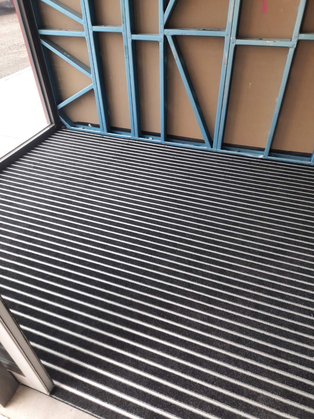 Commercial aluminium ribbed entrance mat installed at the appliance bay roller door threshold