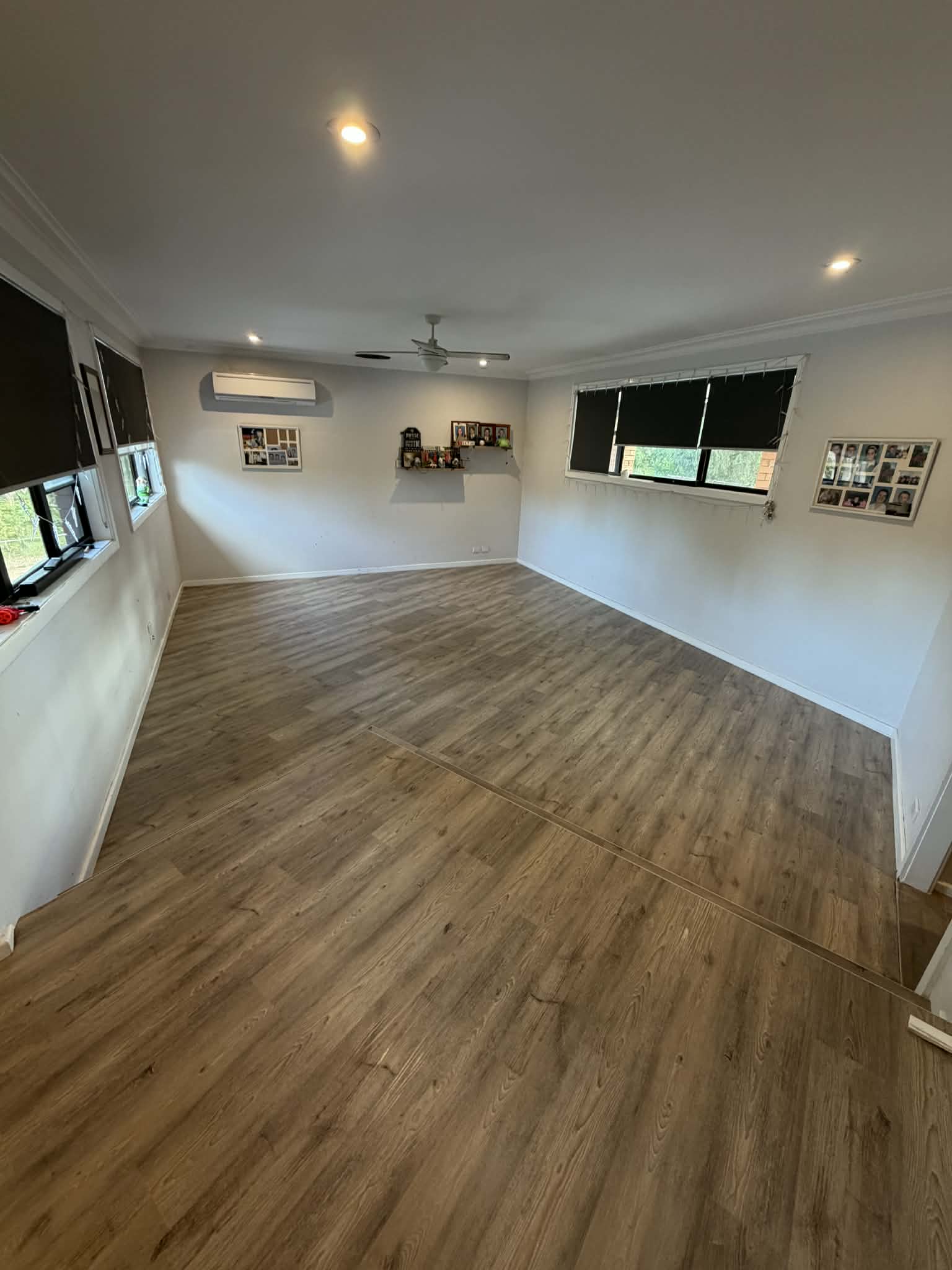 Finished living room with warm brown vinyl plank flooring