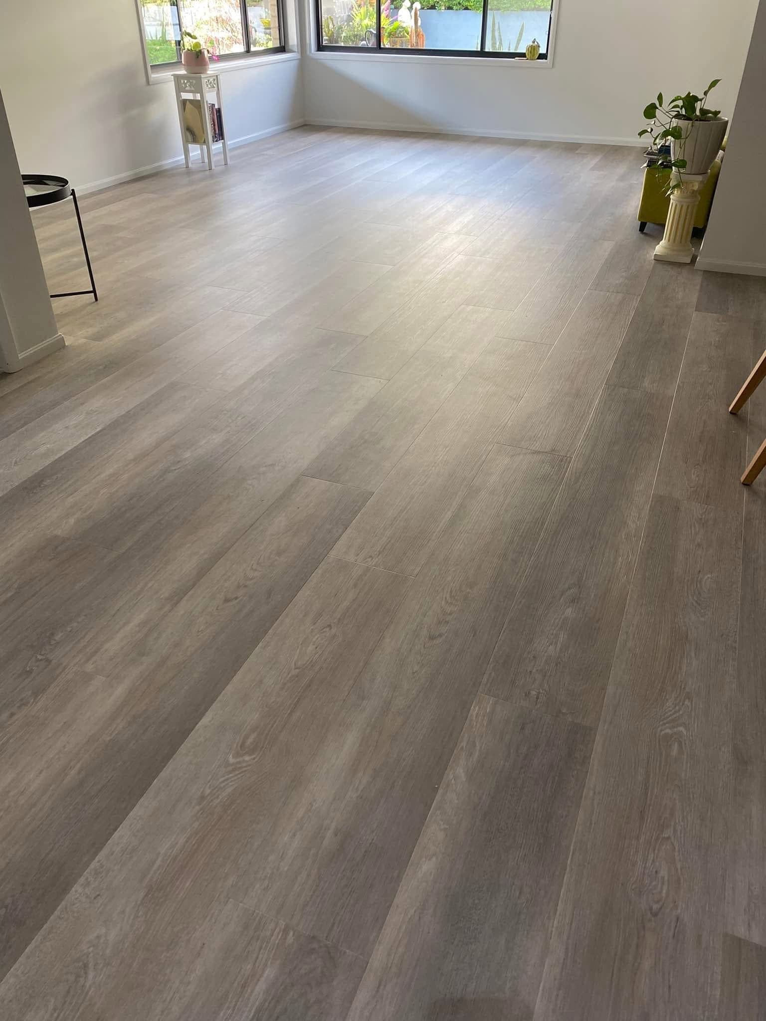 Bright open living area with vinyl plank flooring and large windows