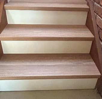 Close-up of new light oak vinyl plank stair treads with white risers