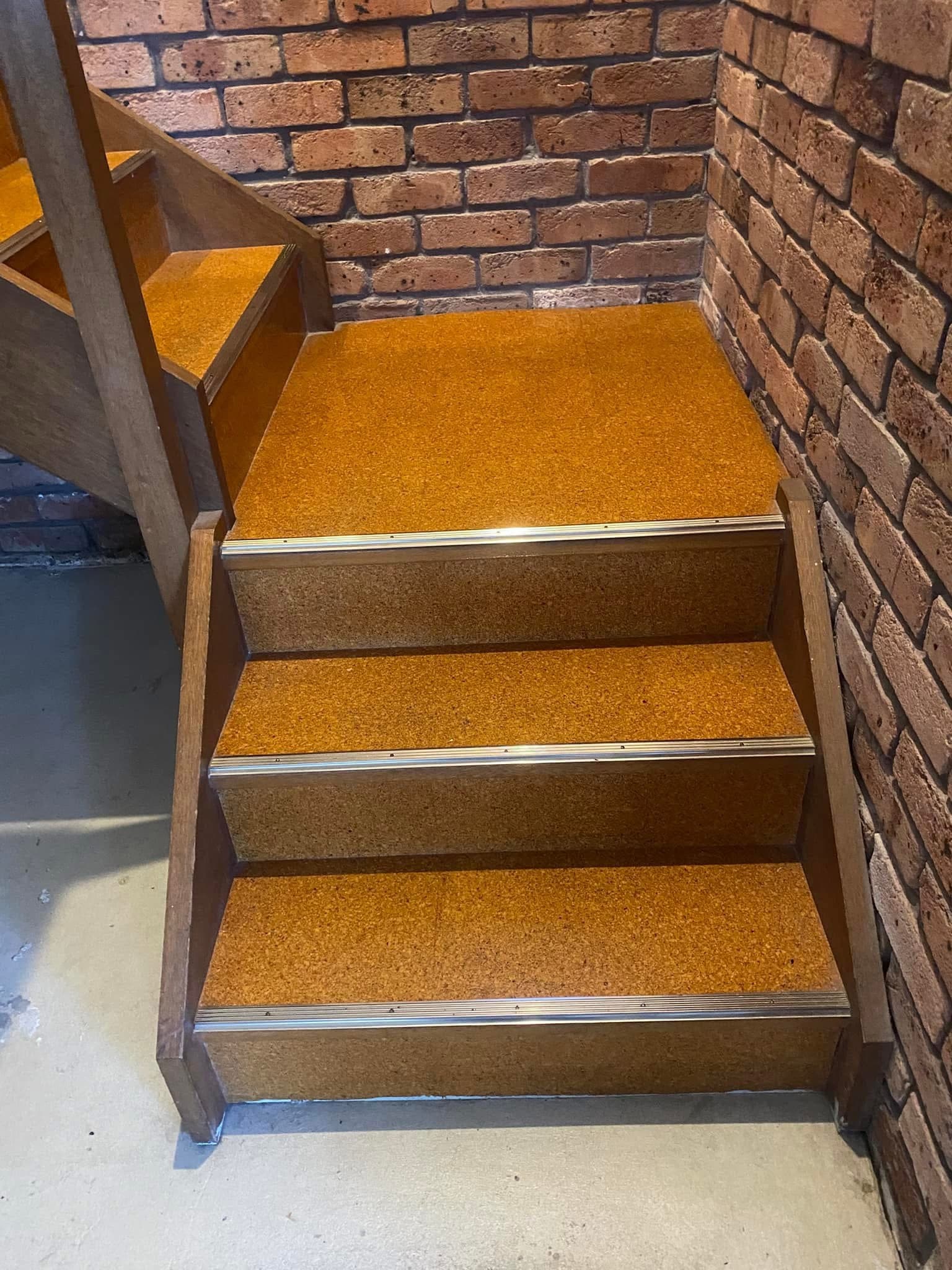 Staircase before renovation — old amber carpet treads with aluminium nosing