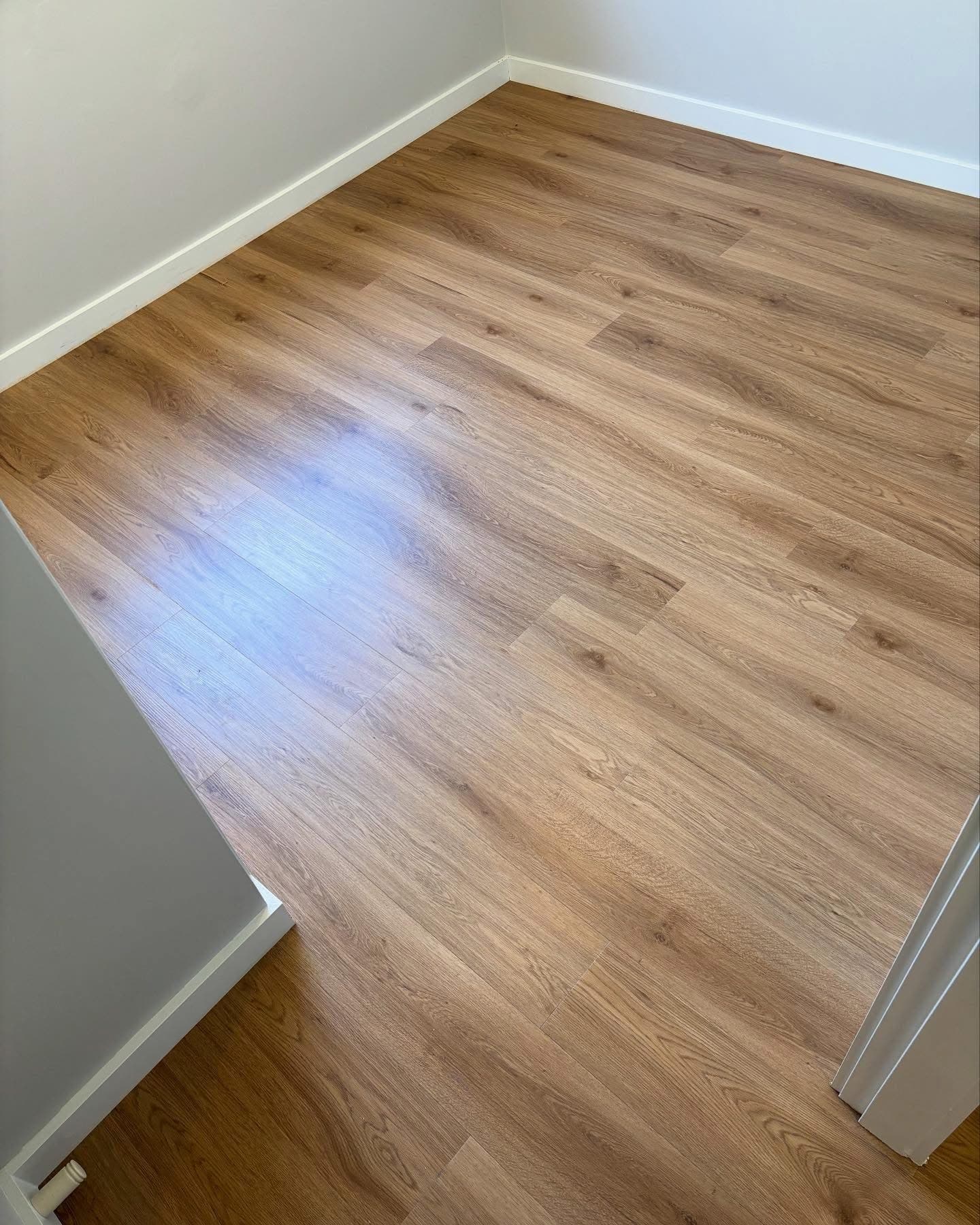 Upper bedroom area with warm honey-toned oak vinyl plank flooring