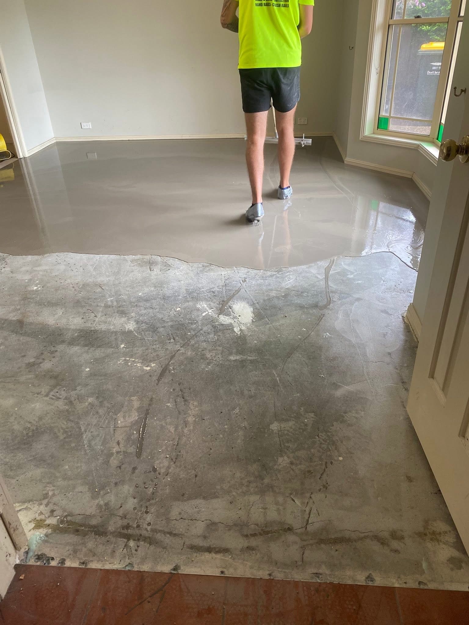 Subfloor preparation — self-levelling compound being applied over stripped concrete
